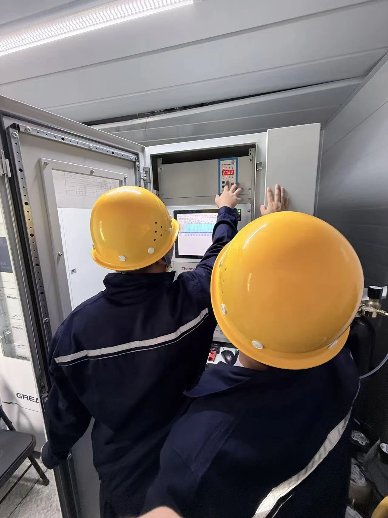 Customer photograph of engineers commissioning an analysis cabinet